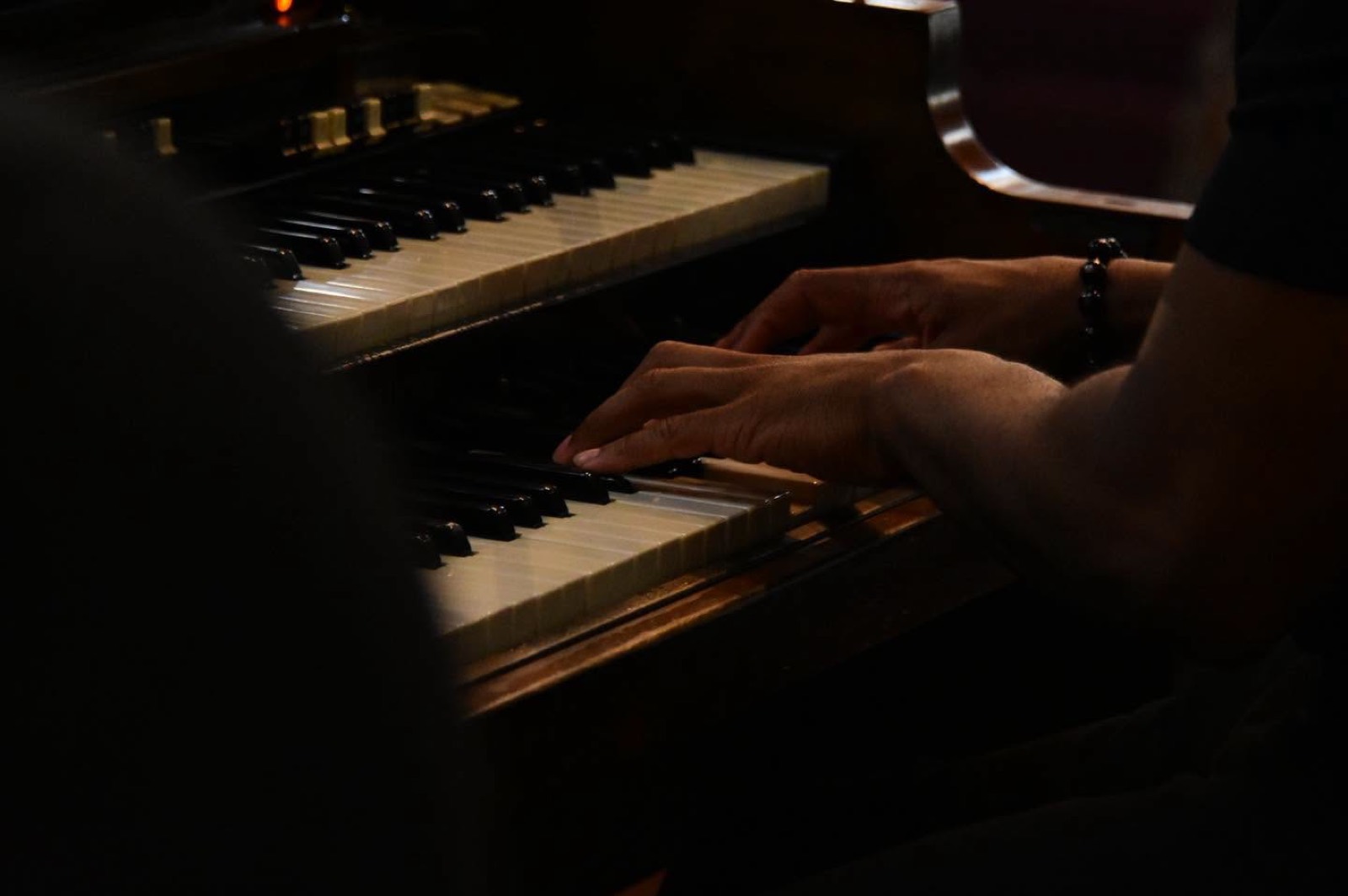 Hands on the piano keys during worship.